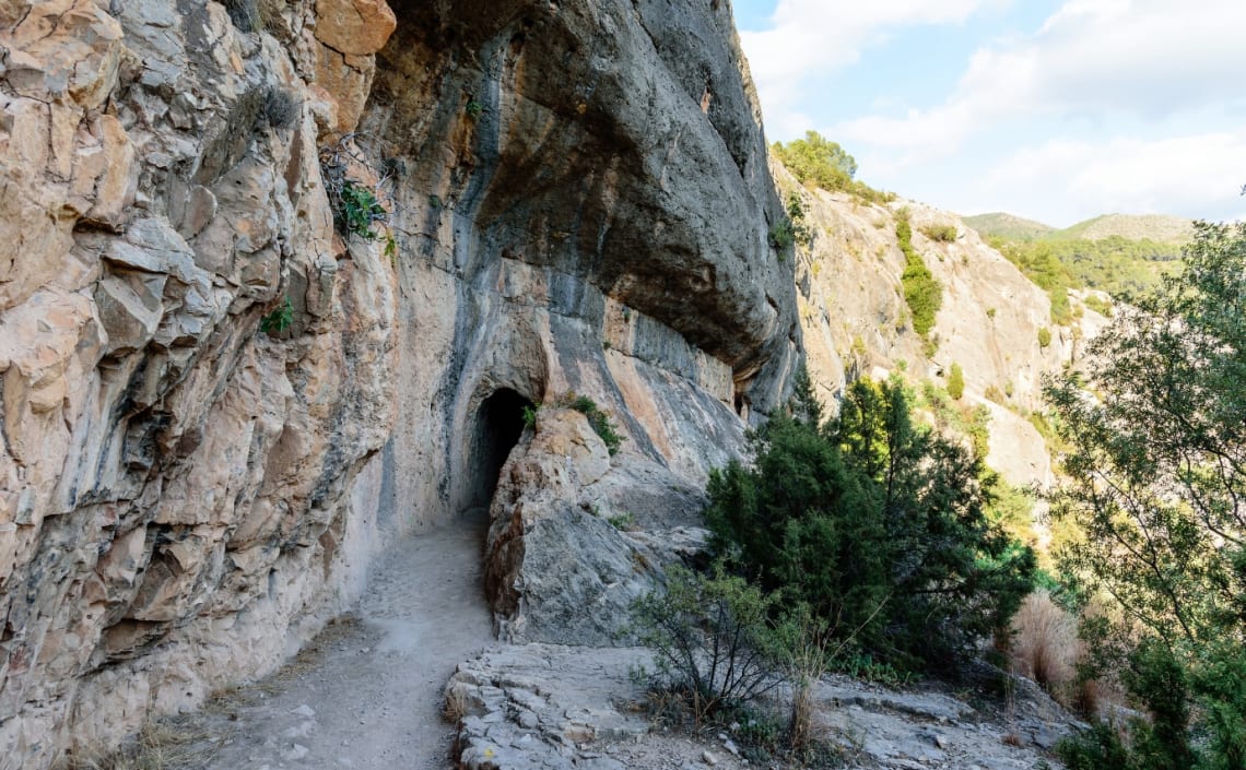 Camino que lleva hacia túnel en la roca de la ruta del Acueducto Romano de Piedra Cortada