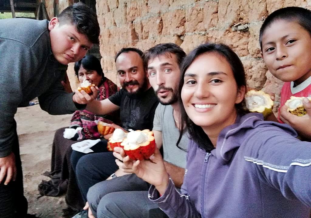 Voluntarios mostrando fruto del cacao en proyecto ambiental en Perú