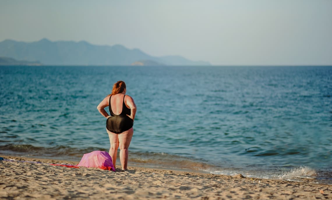 mulher curtindo praia ao viajar sozinha