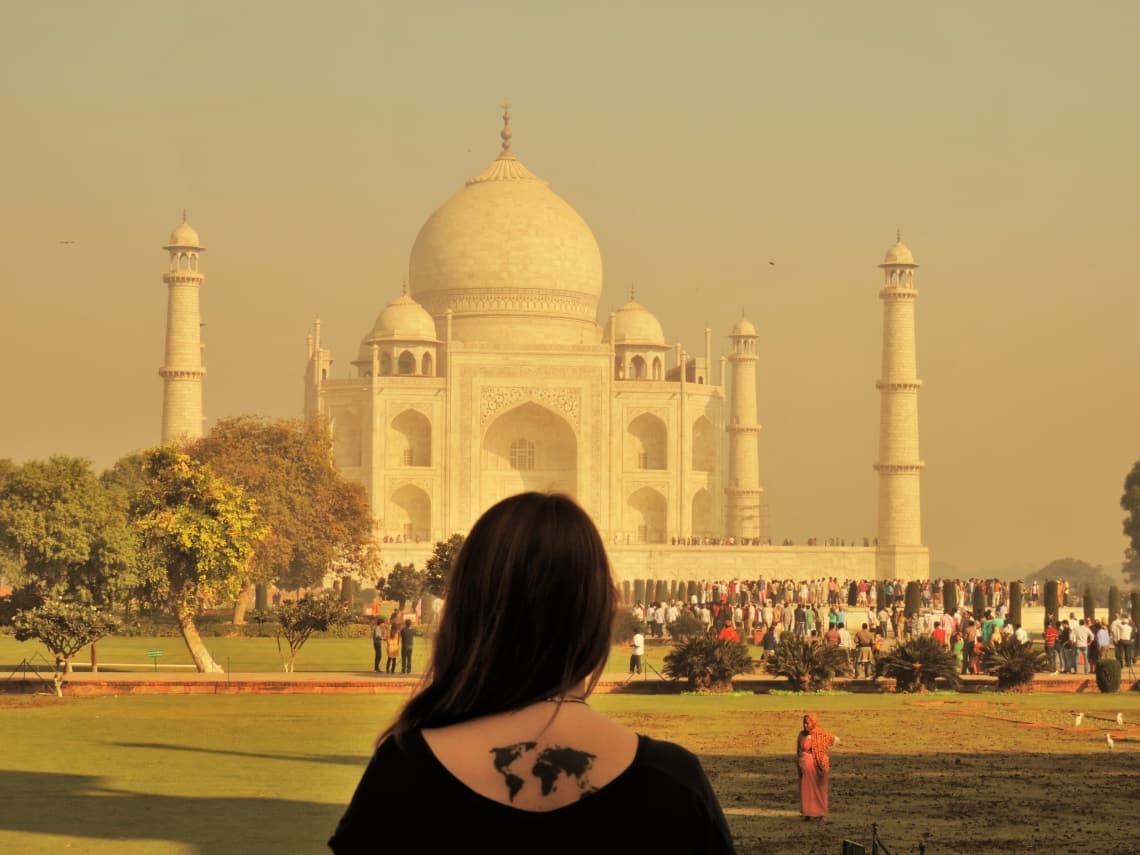 Qué es y cómo funciona un intercambio de trabajo: la guía completa - Worldpackers - mujer en el taj mahal con tatuaje en la espalda  