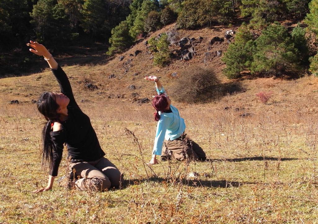 Dos chicas haciendo yoga en ambiente rural