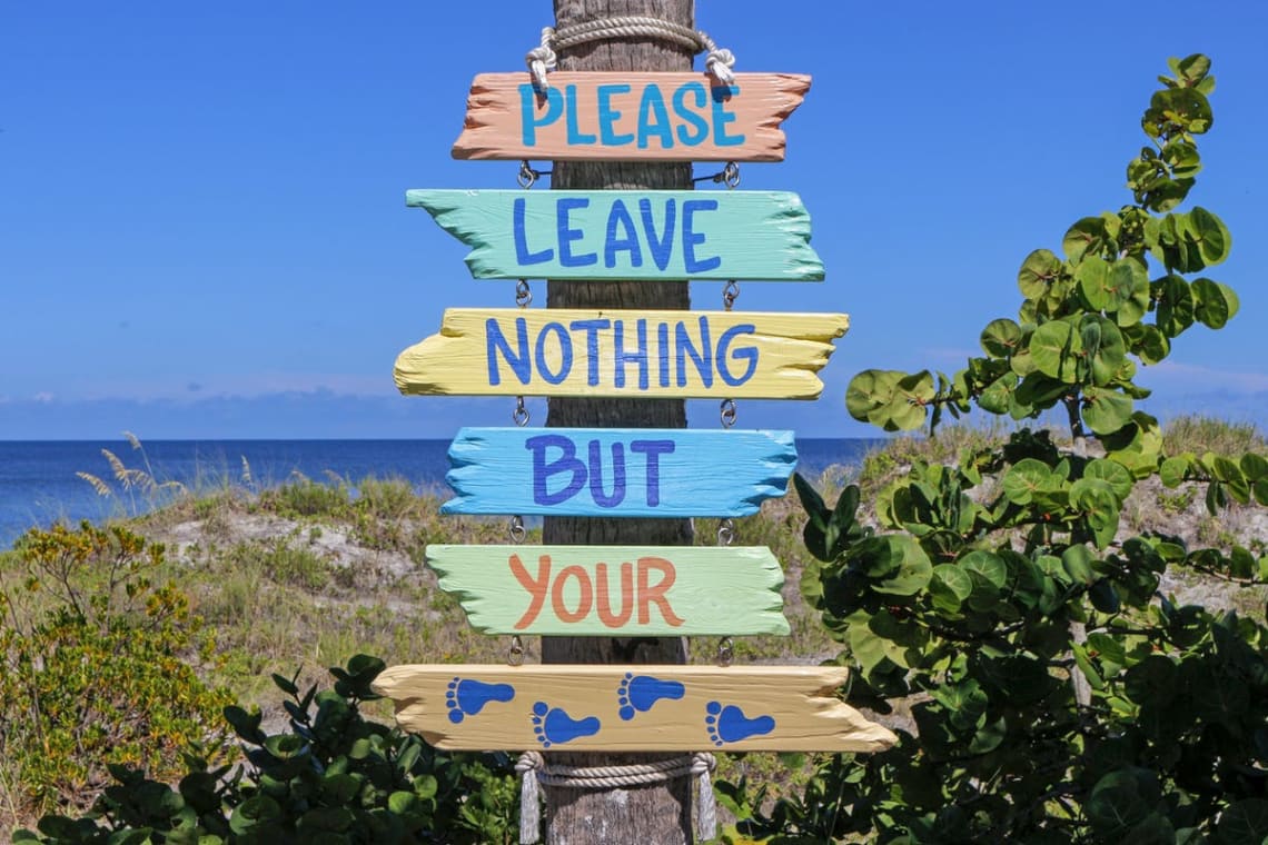 "Please leave nothing but your footsteps" sign in a beach