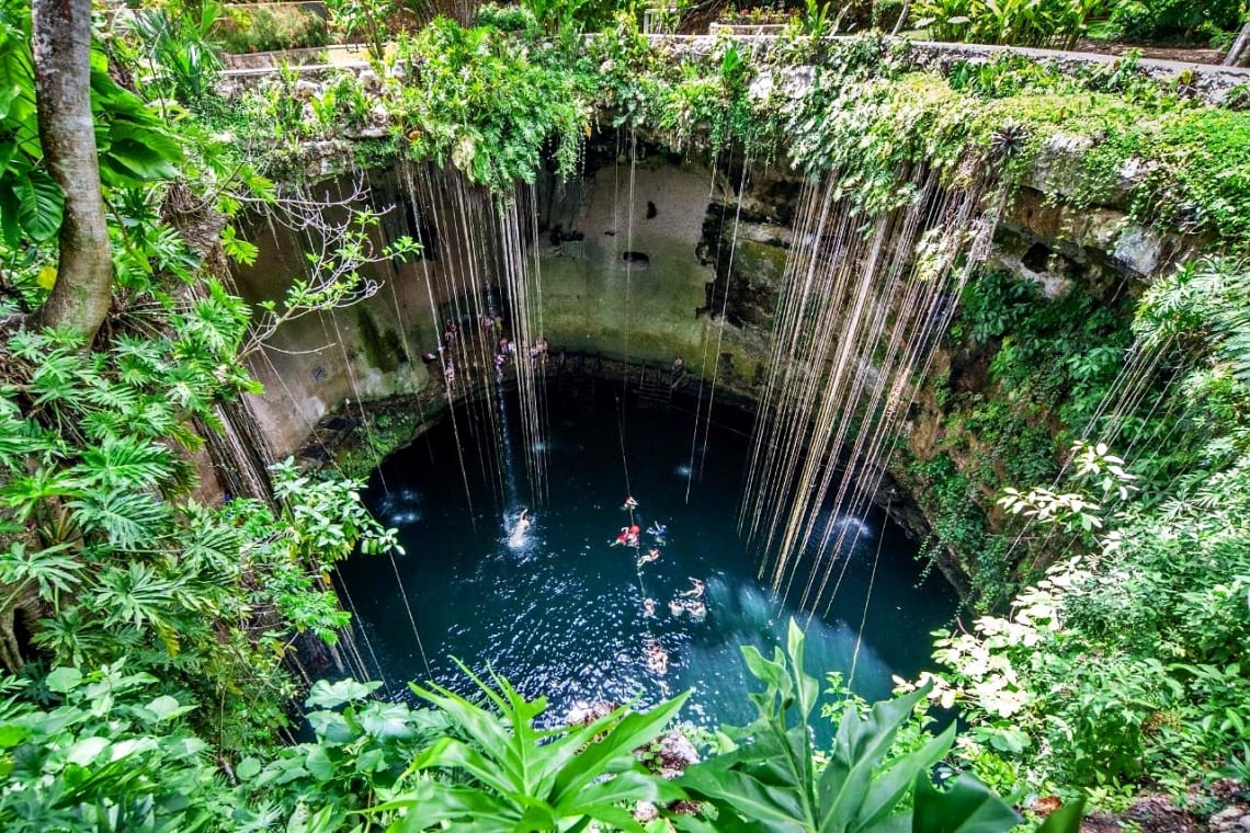 Vista desde lo alto del cenote Ik-kil con raíces colgando hacia su interior