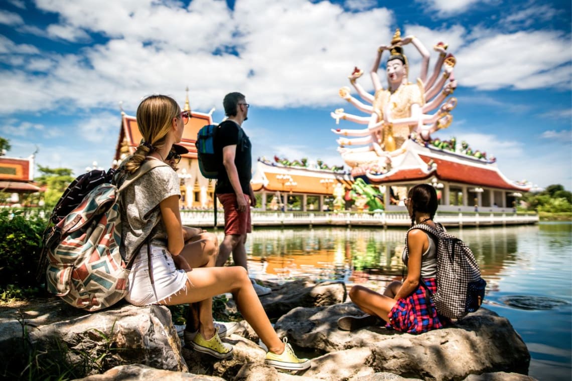 Jóvenes mirando un templo budista de Tailandia, uno de los mejores países para trabajar