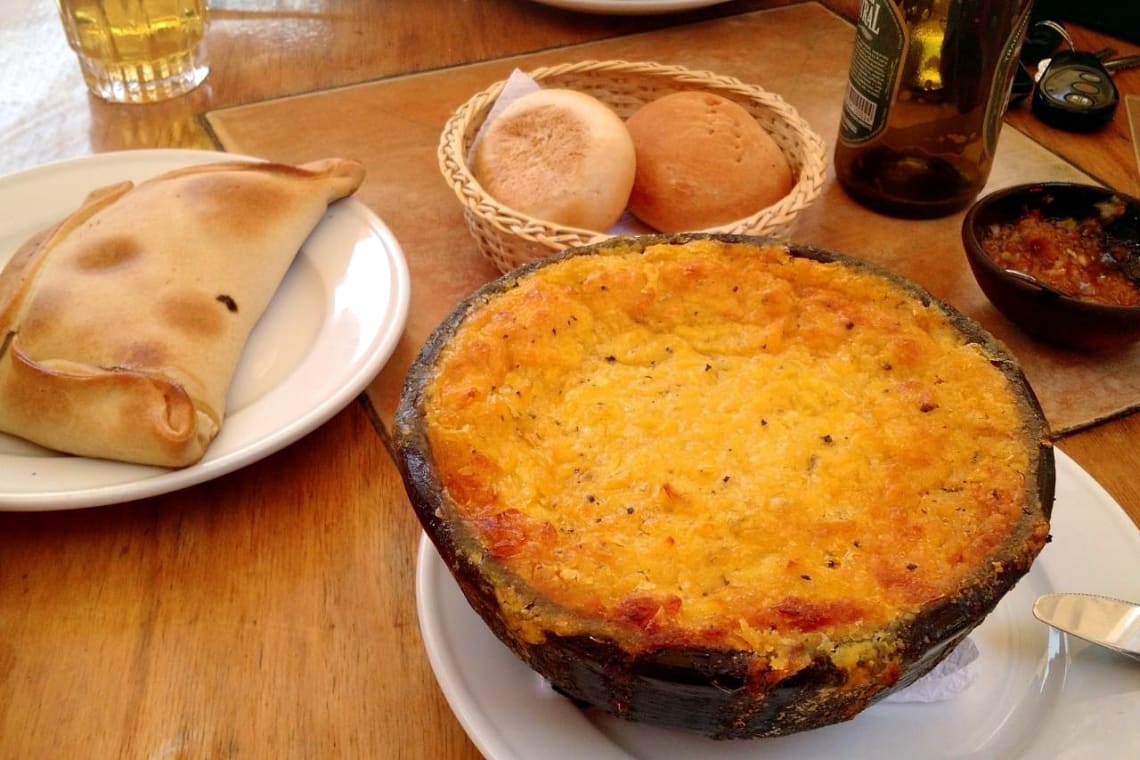 Mesa de restaurante con empanada y pastel de choclo