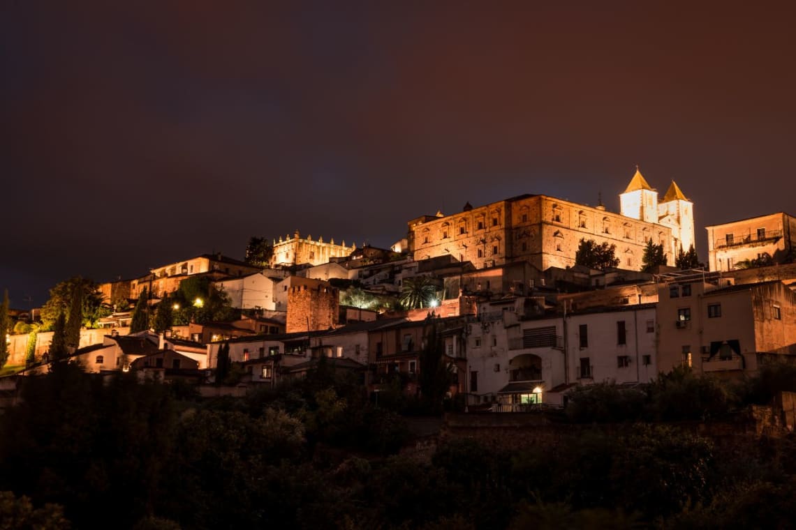 Qué ver en Extremadura: Vista de centro histórico de Cáceres iluminado por la noche