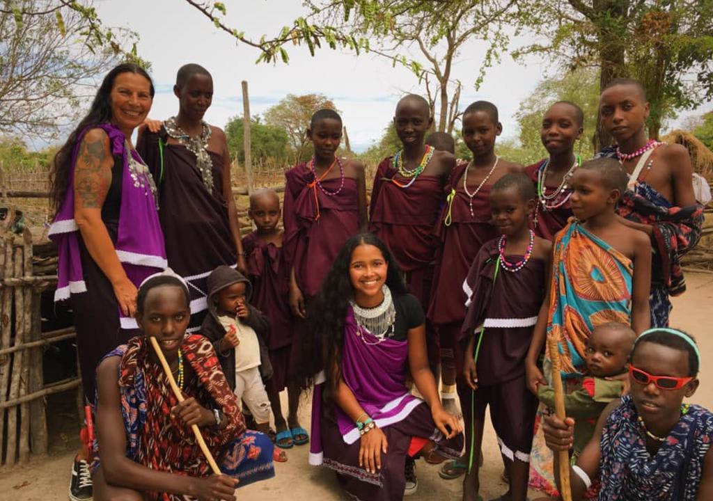 Madre e hija latinas junto a tribu africana como parte de un intercambio cultural