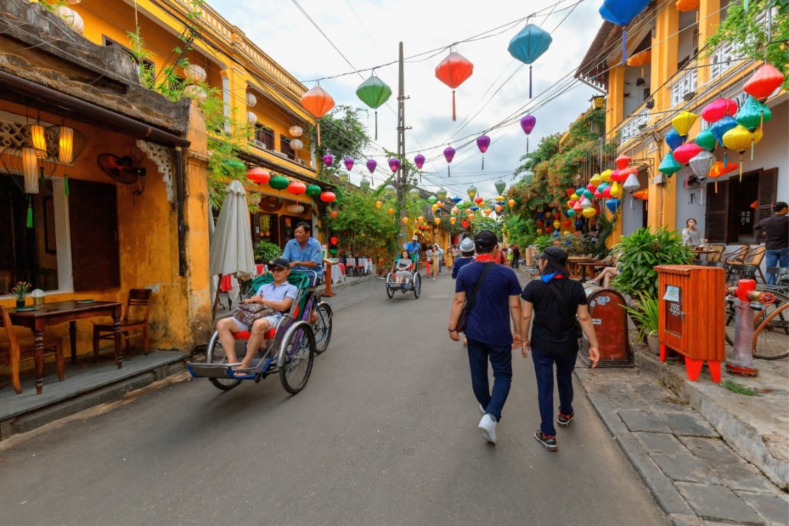 Turistas paseando por colorido casco antiguo de Hoi An