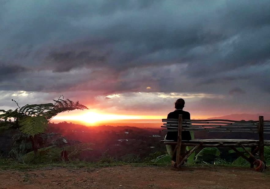 Guy in a lookout watching the sunset