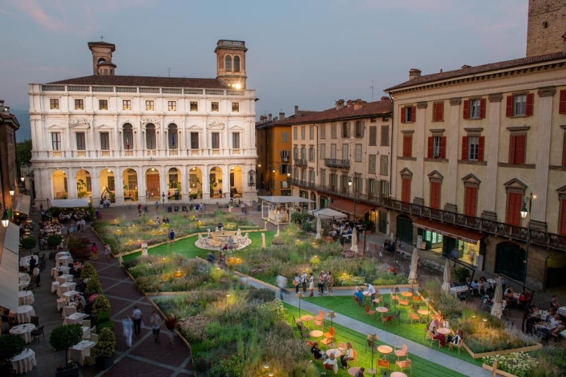 Plaza de Bérgamo rodeada de edificios por la noche