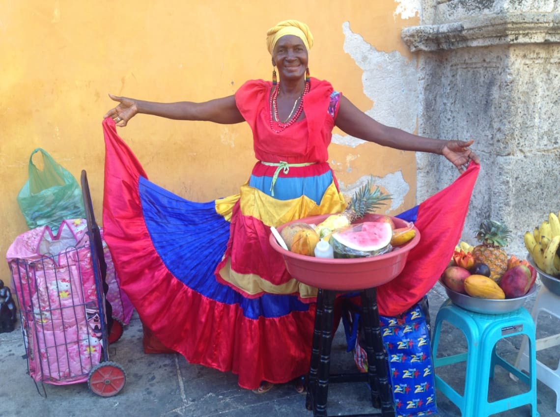 Vendedora de frutas con colorido vestido tradicional