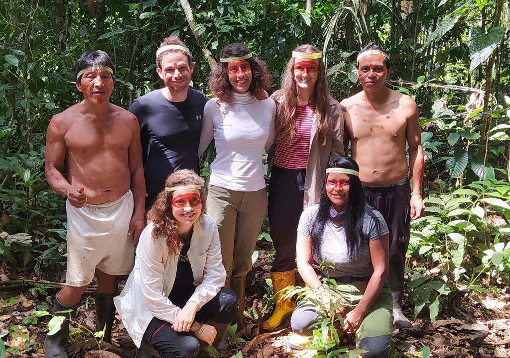 Three volunteer girls and a guy with people from a local community from the Amazon jungle