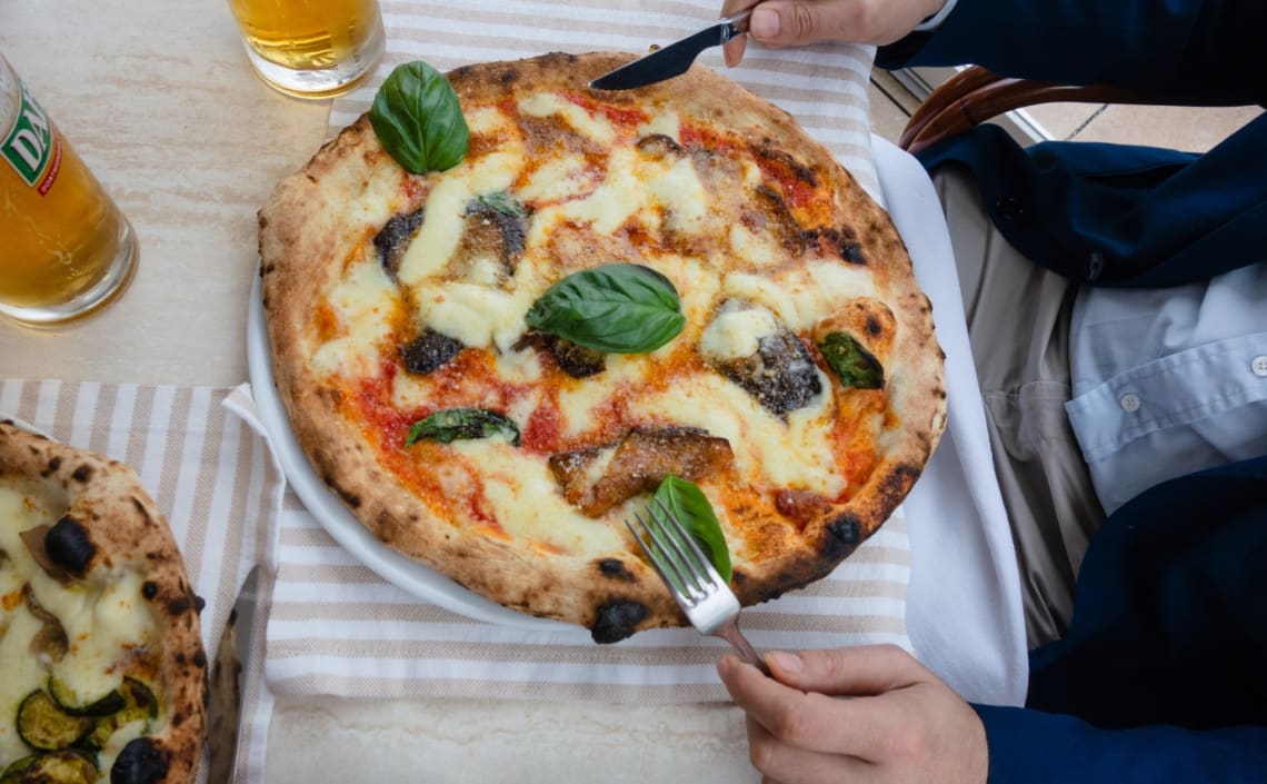 Hombre comiendo pizza napolitana