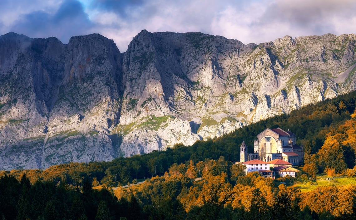 Iglesia rodeada de naturaleza y paredones de piedra detrás en Urkiola