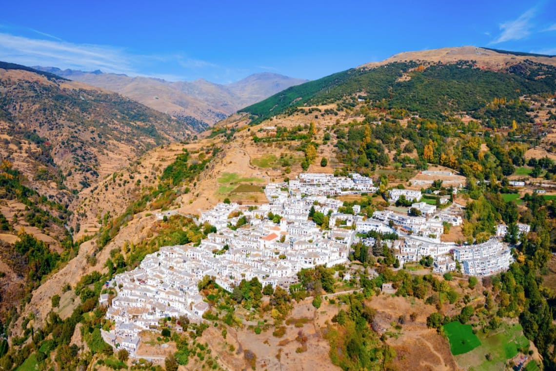 Vista aérea de pueblo de casas blancas Capileira en zona de montaña