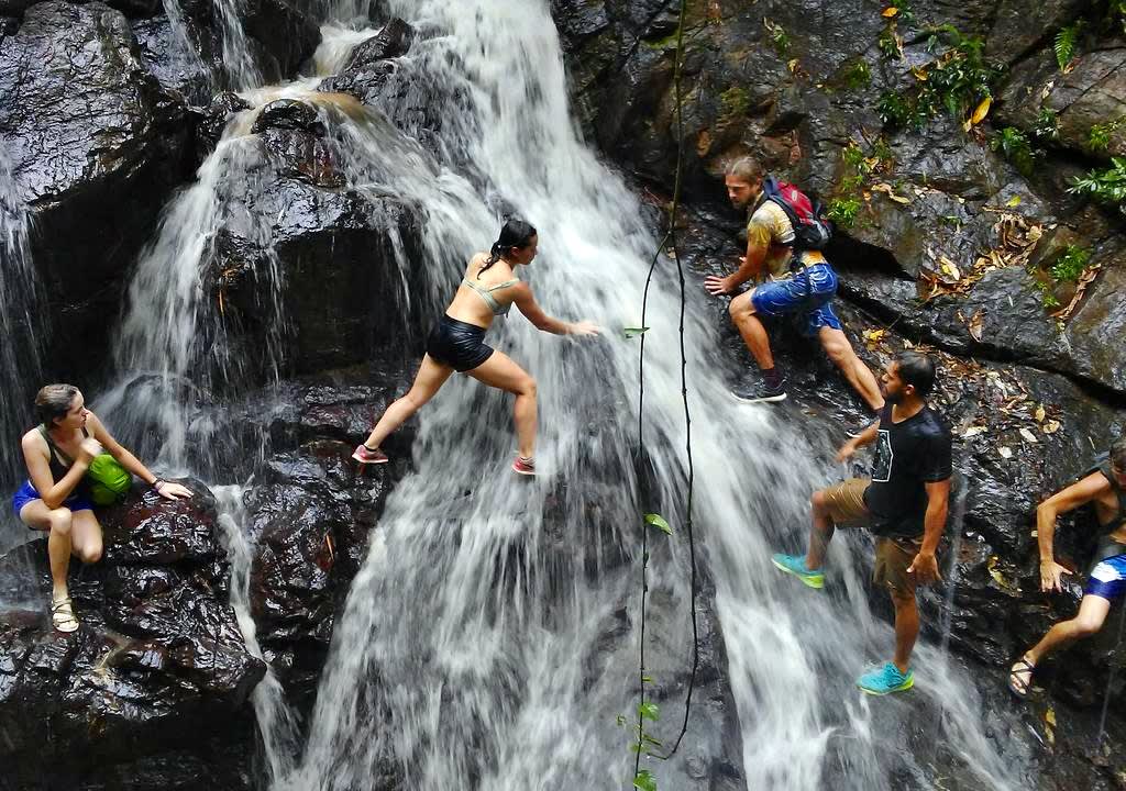 Travelers crossing a waterfall through rocks in Puerto Rico