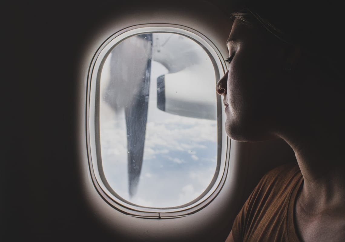 Female traveler looking out of airplane window