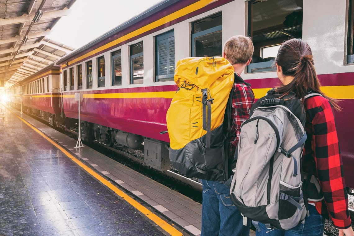 Travelers with backpacks waiting for the train