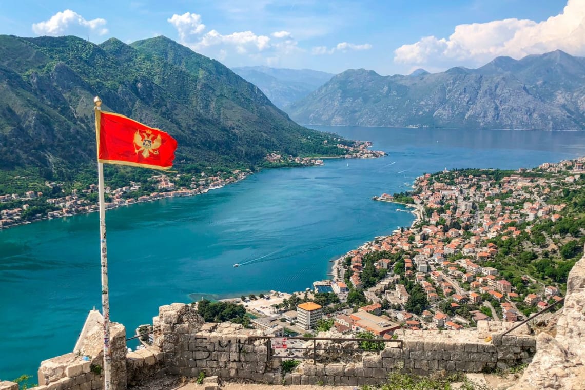 Montengro flag in a lookout point with views to a mountain lake