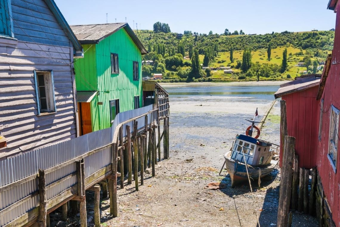 Palafitos y barco a orillas de entrada de mar