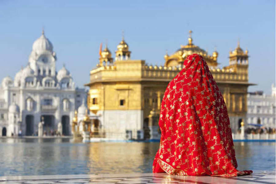 A woman in a red dupatta at the Golden Temple, Amritsar