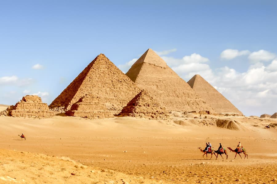 Camels passing the pyramids of Giza, Egypt