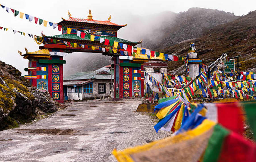 A painted gateway hung with prayer flags in Arunachal Pradesh