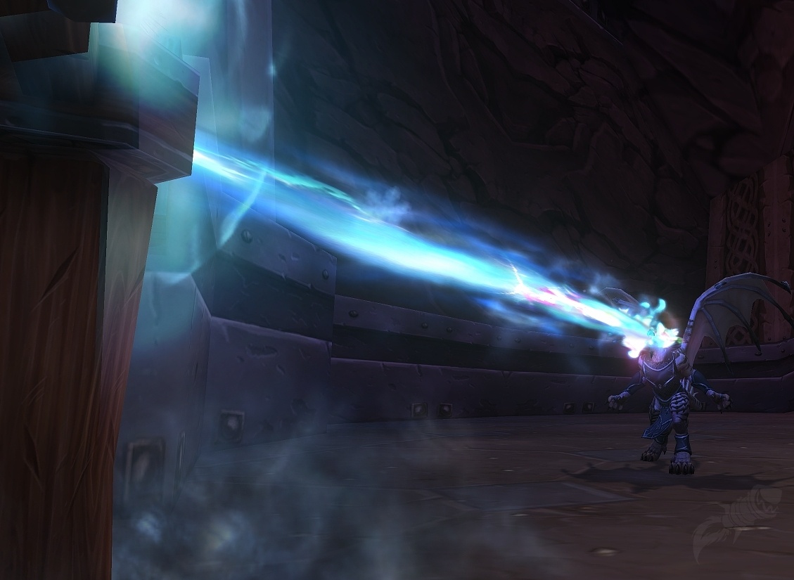 A Dracthyr Evoker channels the blue Disintegrate beam at an enemy inside a World of Warcraft dungeon.