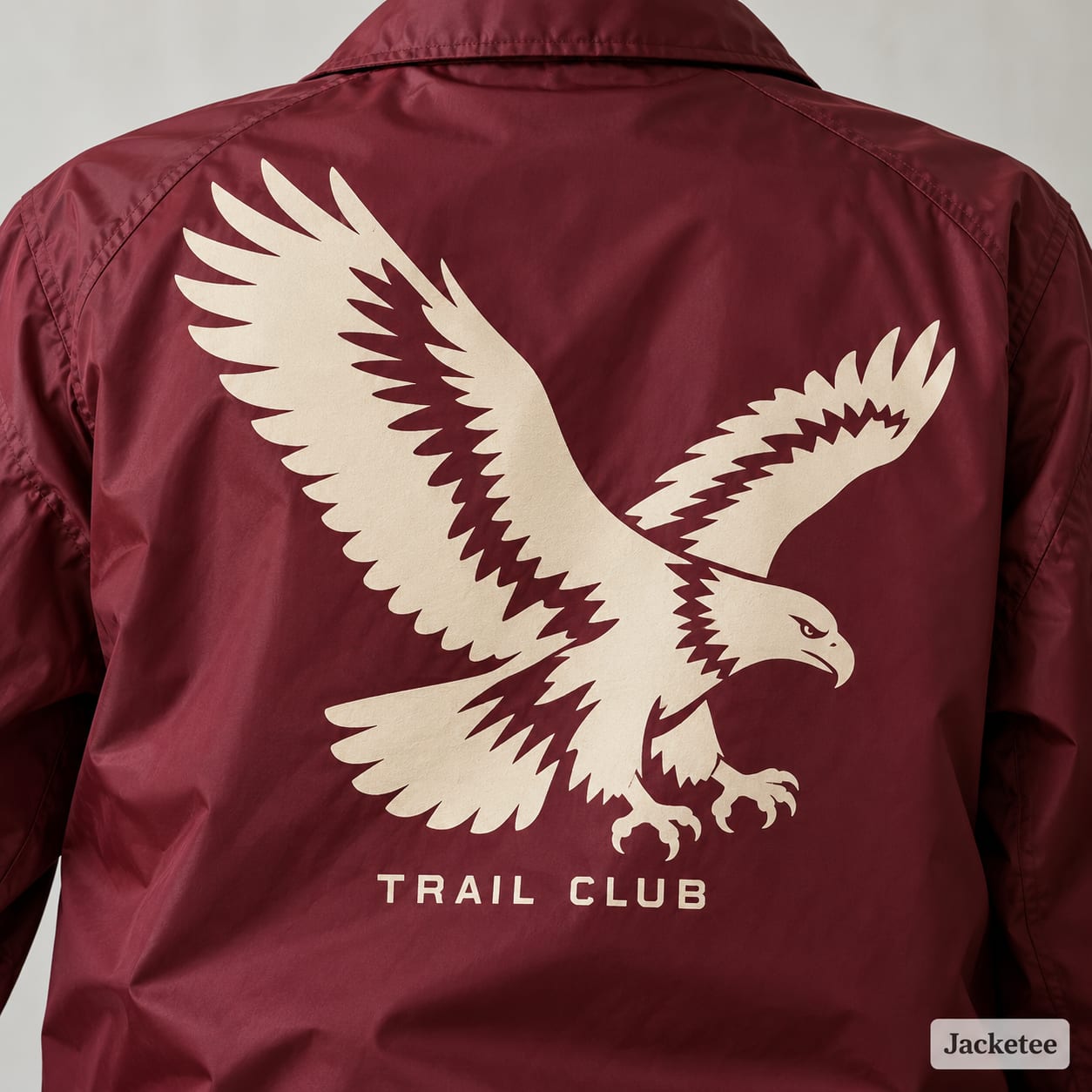 Cream eagle and Trail Club screen print on a burgundy jacket back