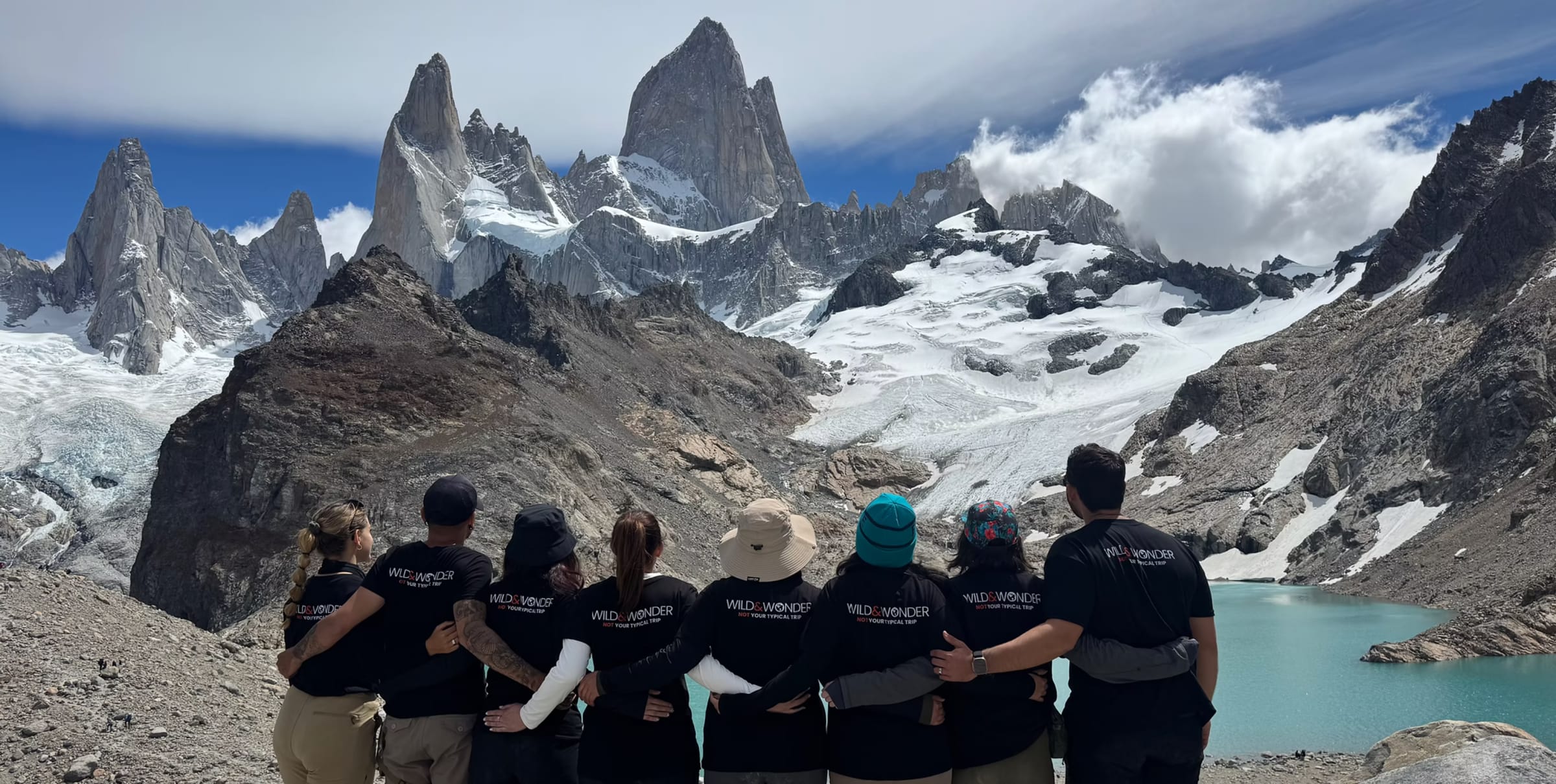 Wild & Wonder group embracing while looking at Fitz Roy in Patagonia