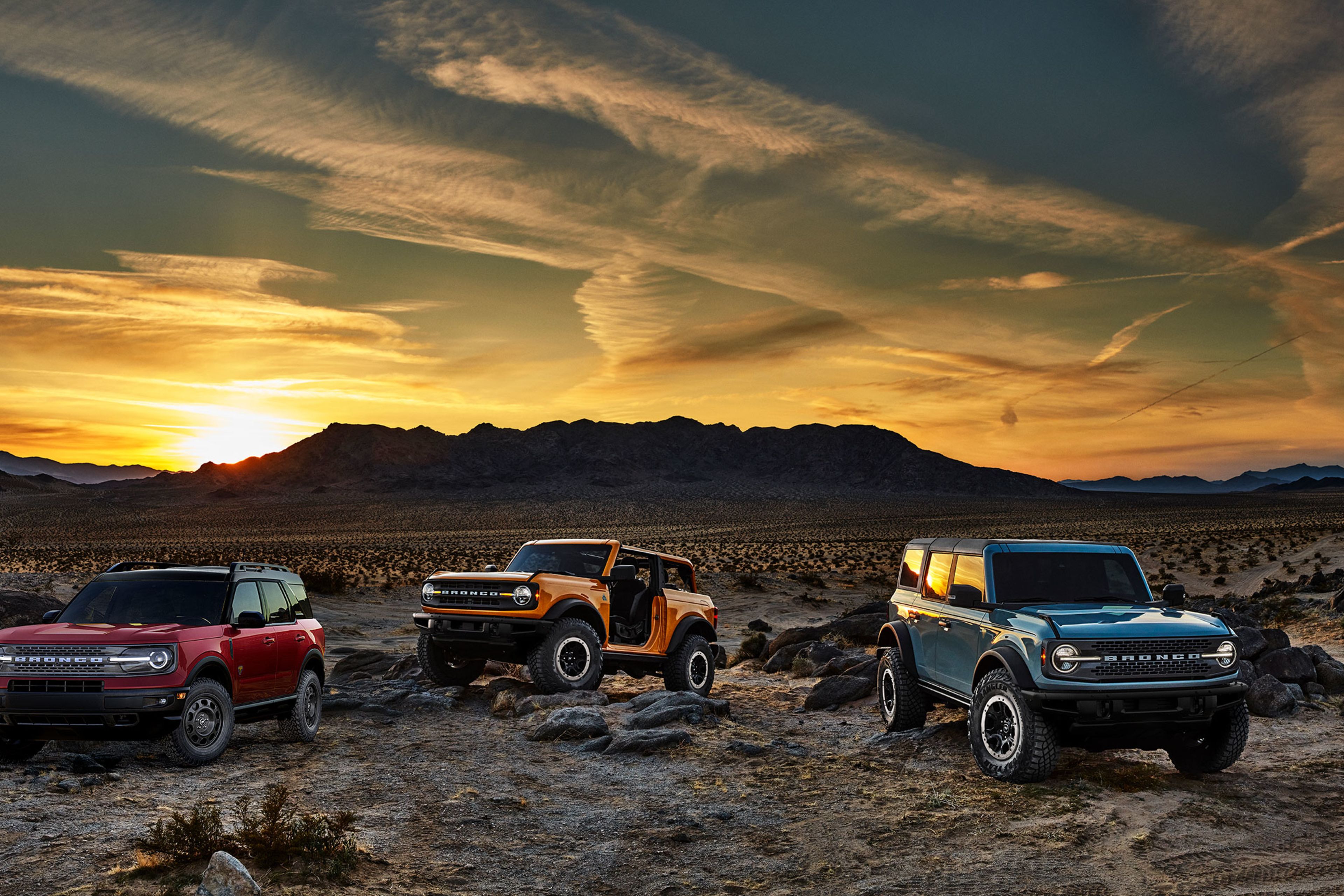 Photograph of three Ford Broncho cars in the desert