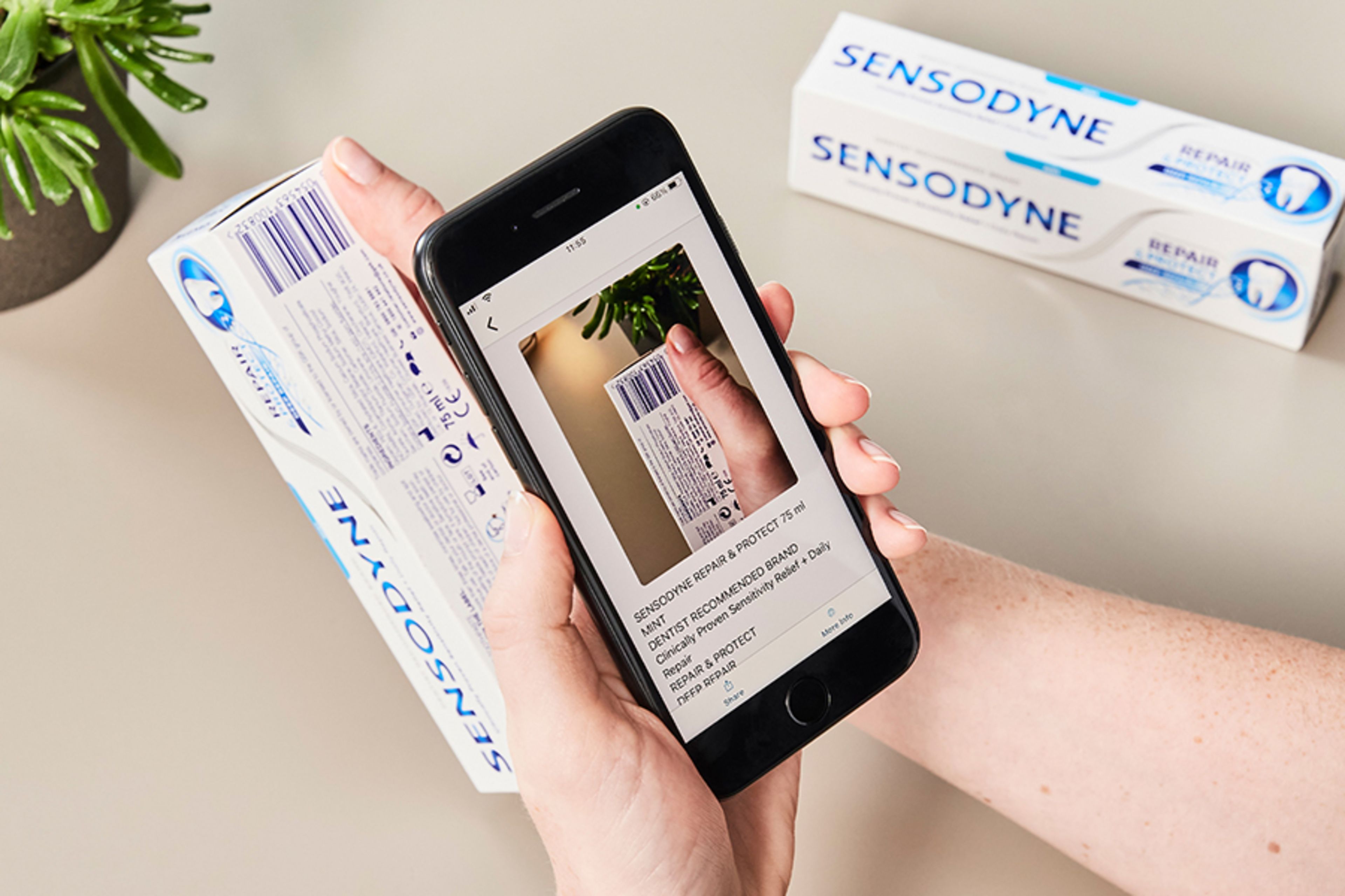 Someone with a phone scanning a barcode on a toothpaste packet to read the label with Seeing AI