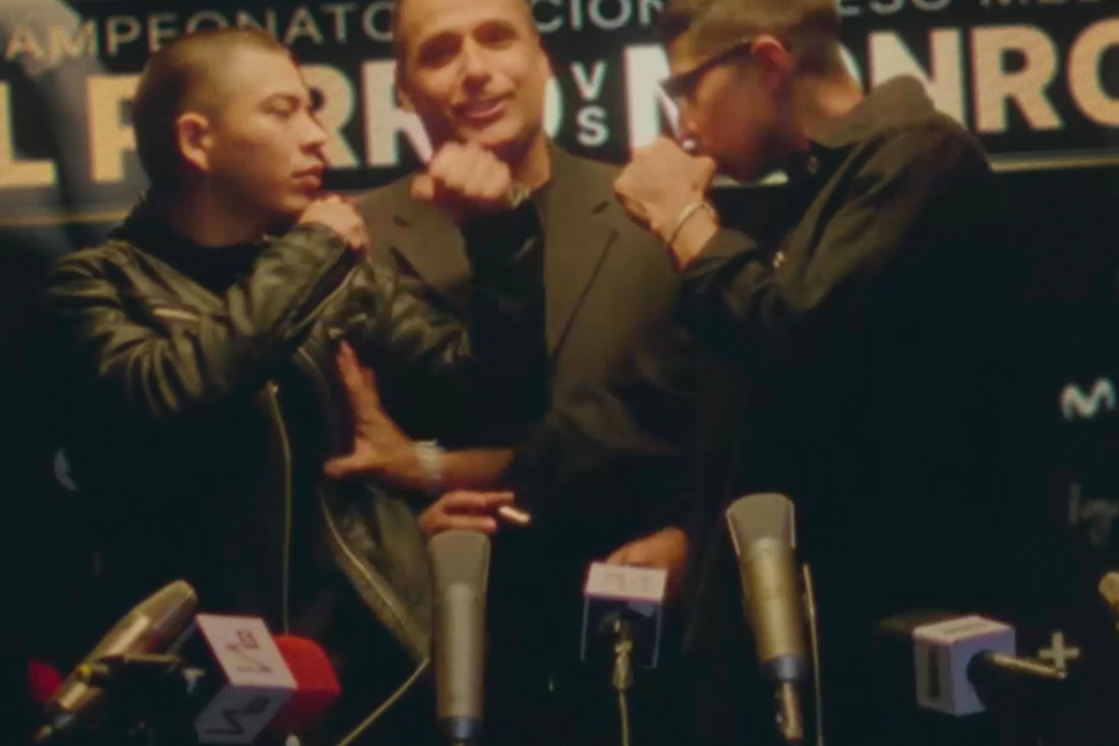 Three boxers standing in front of microphones / at a press conference