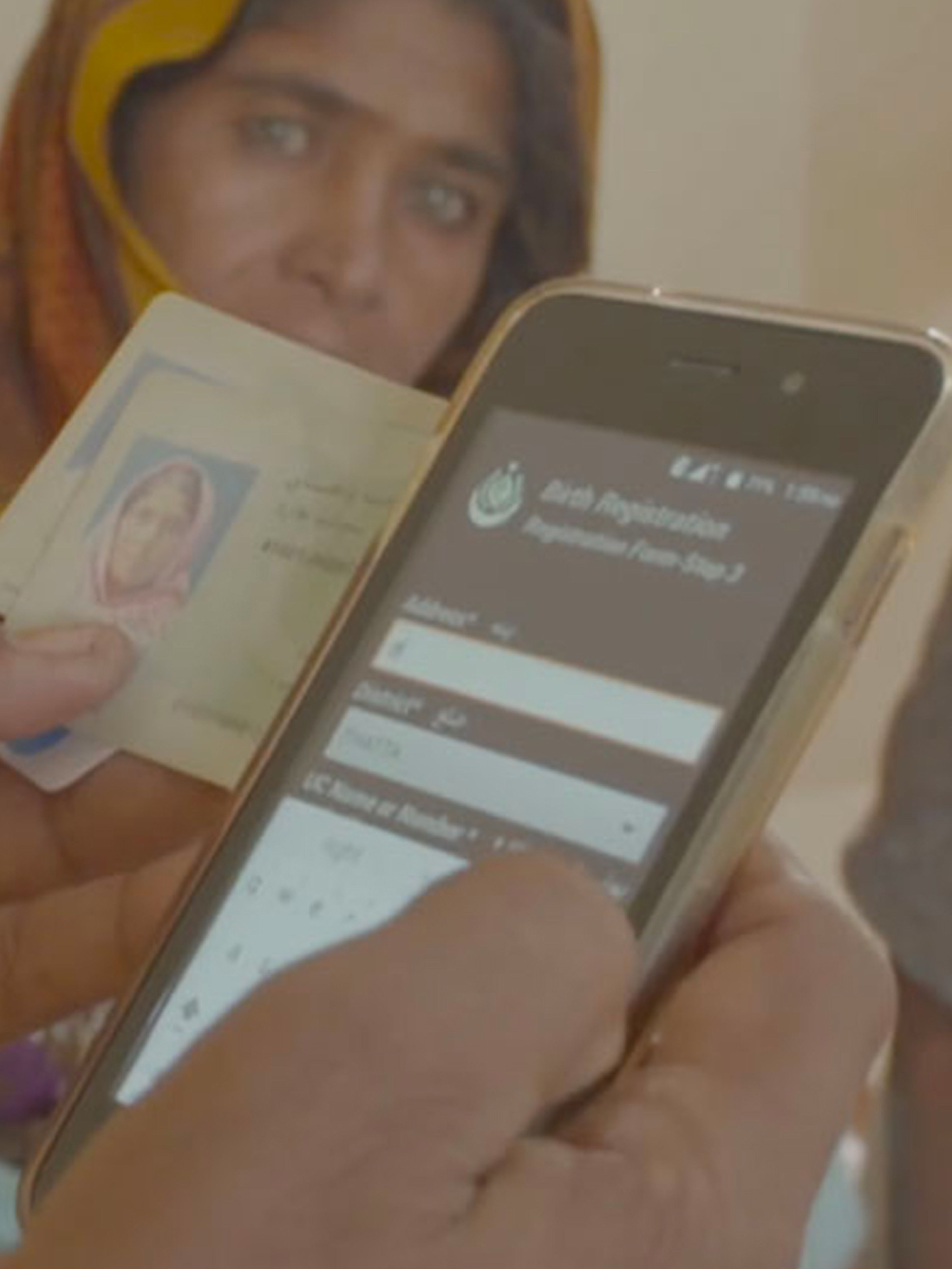 Someone filling out form on mobile phone with woman's face in the background