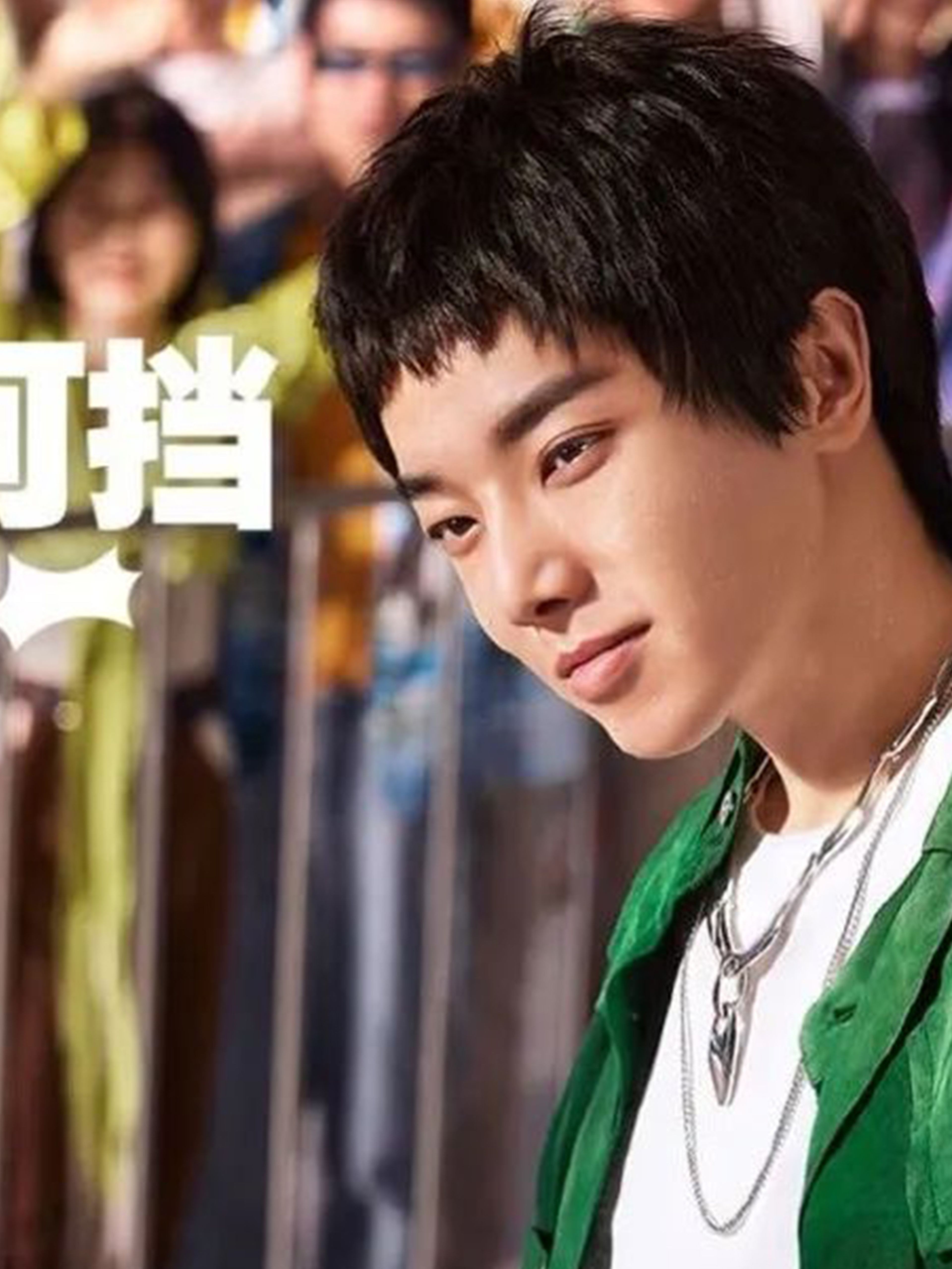 Hua Chenyu looking at a Sprite bottle on stage in front of a crowd