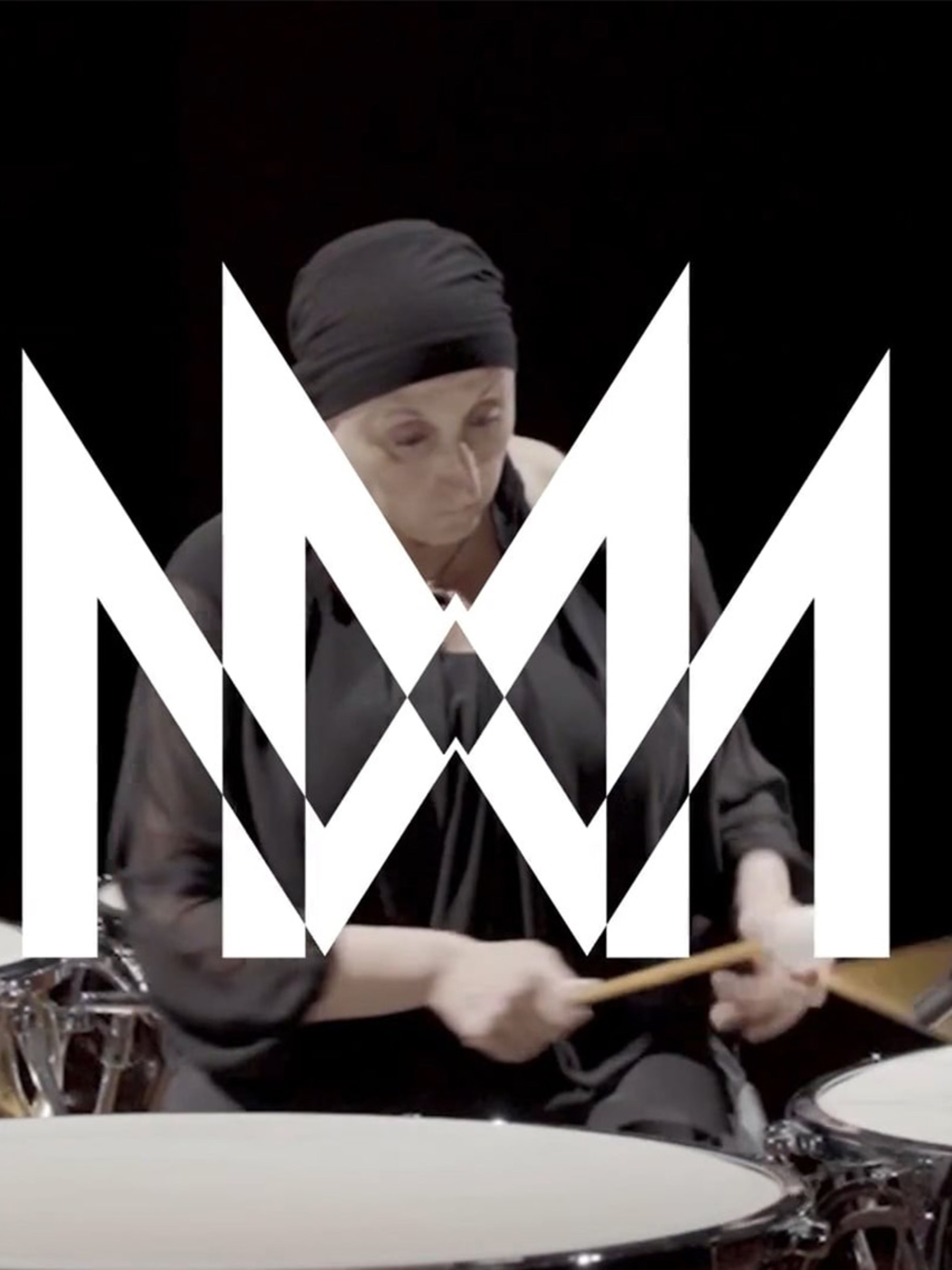 Woman wearing black playing the drums with the Milan Symphony Orchestra logo in white