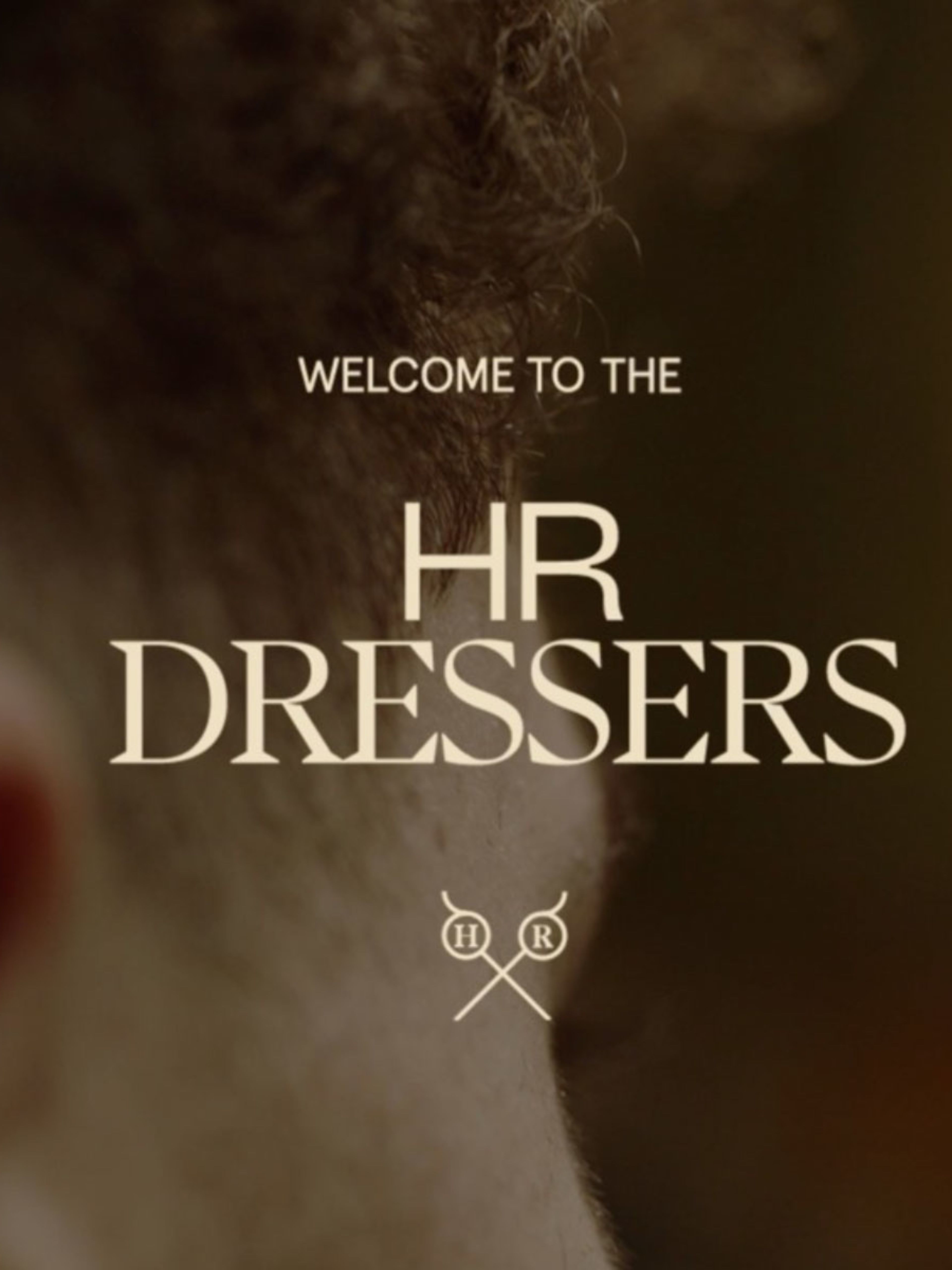 Close up of the side of a mans head blurred in the background with 'Welcome to the HR Dressers' overlayed in yellow text