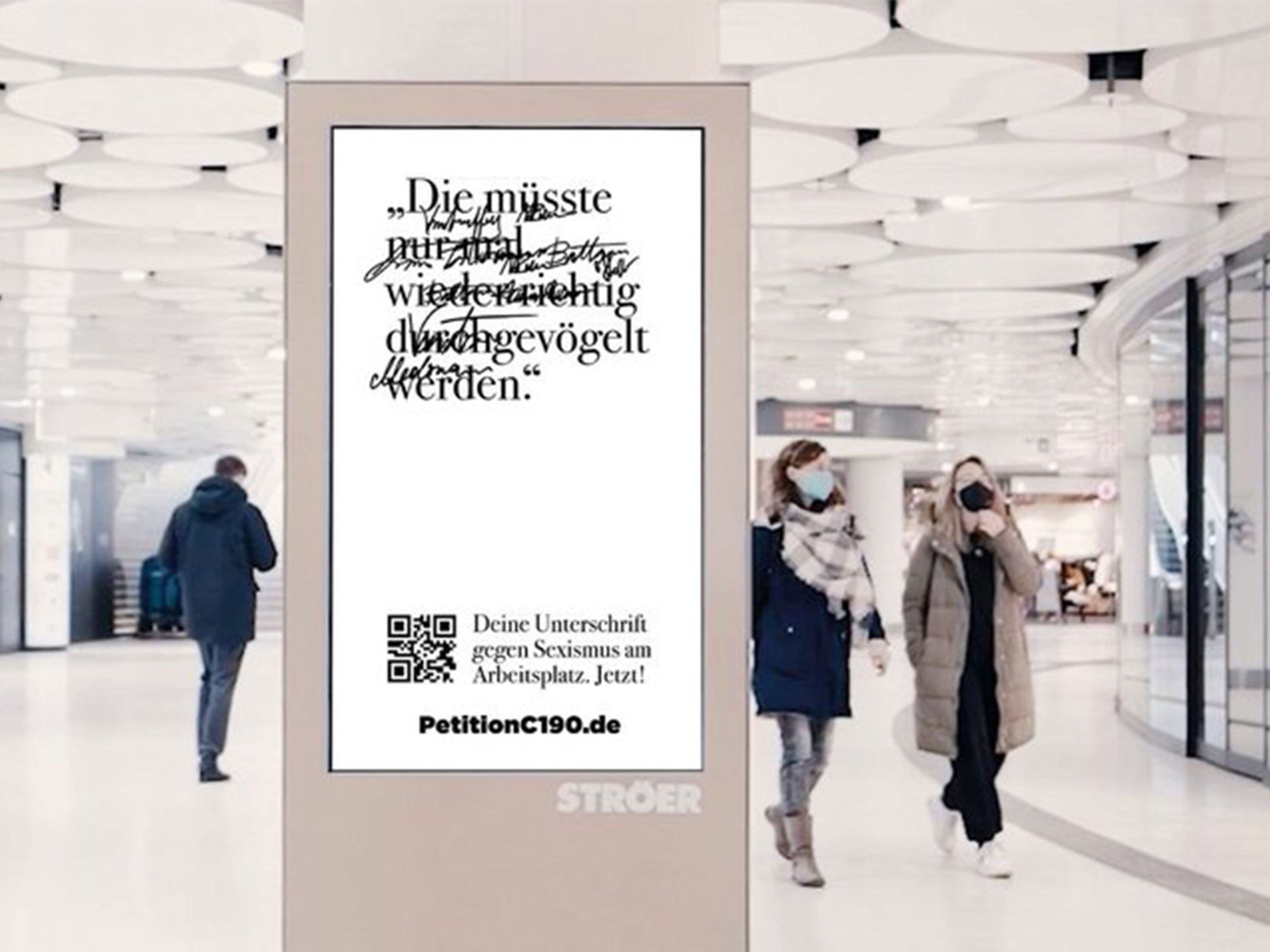 Digital billboard with people walking around in a light and bright mall space