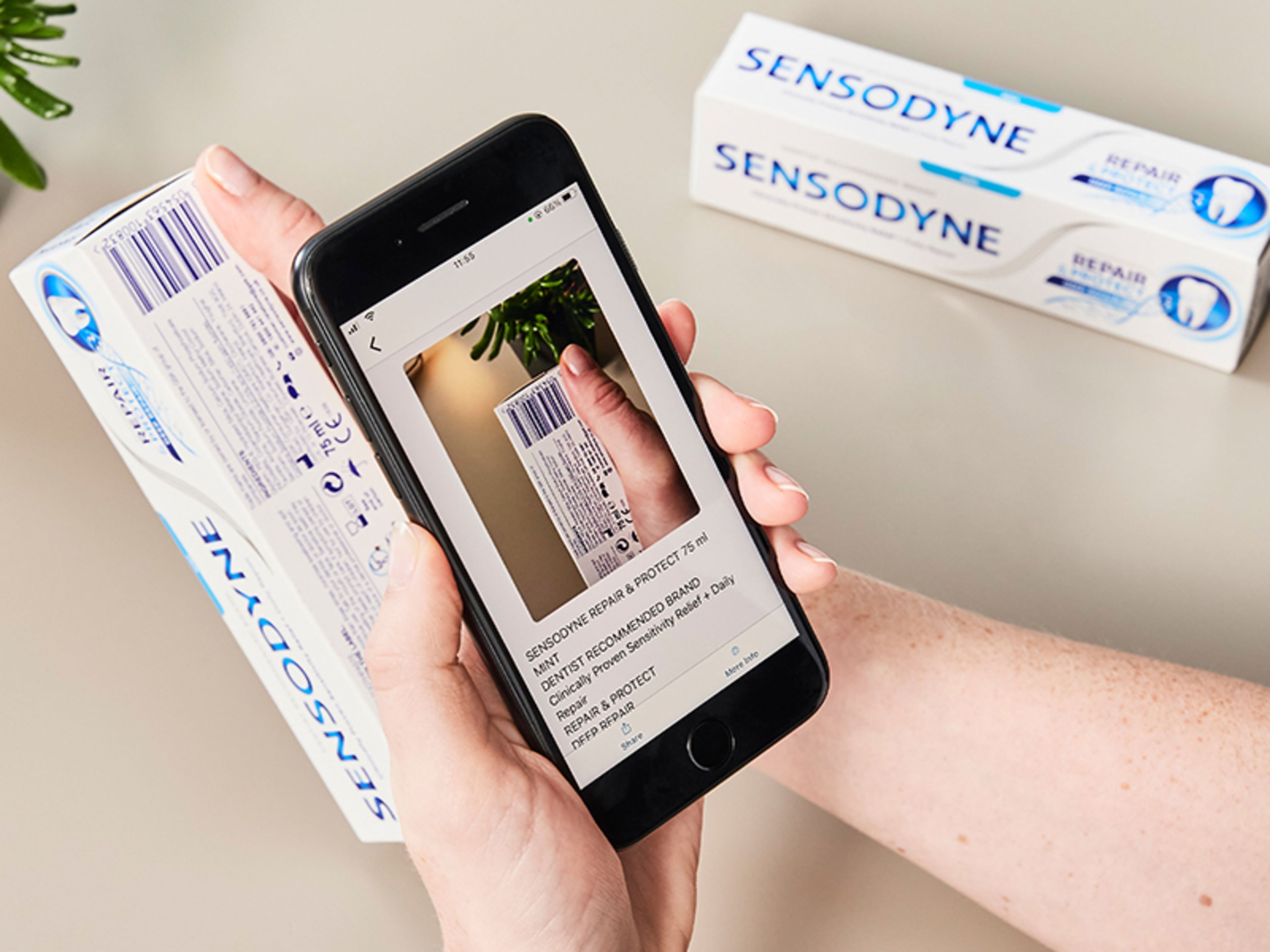 Someone with a phone scanning a barcode on a toothpaste packet to read the label with Seeing AI