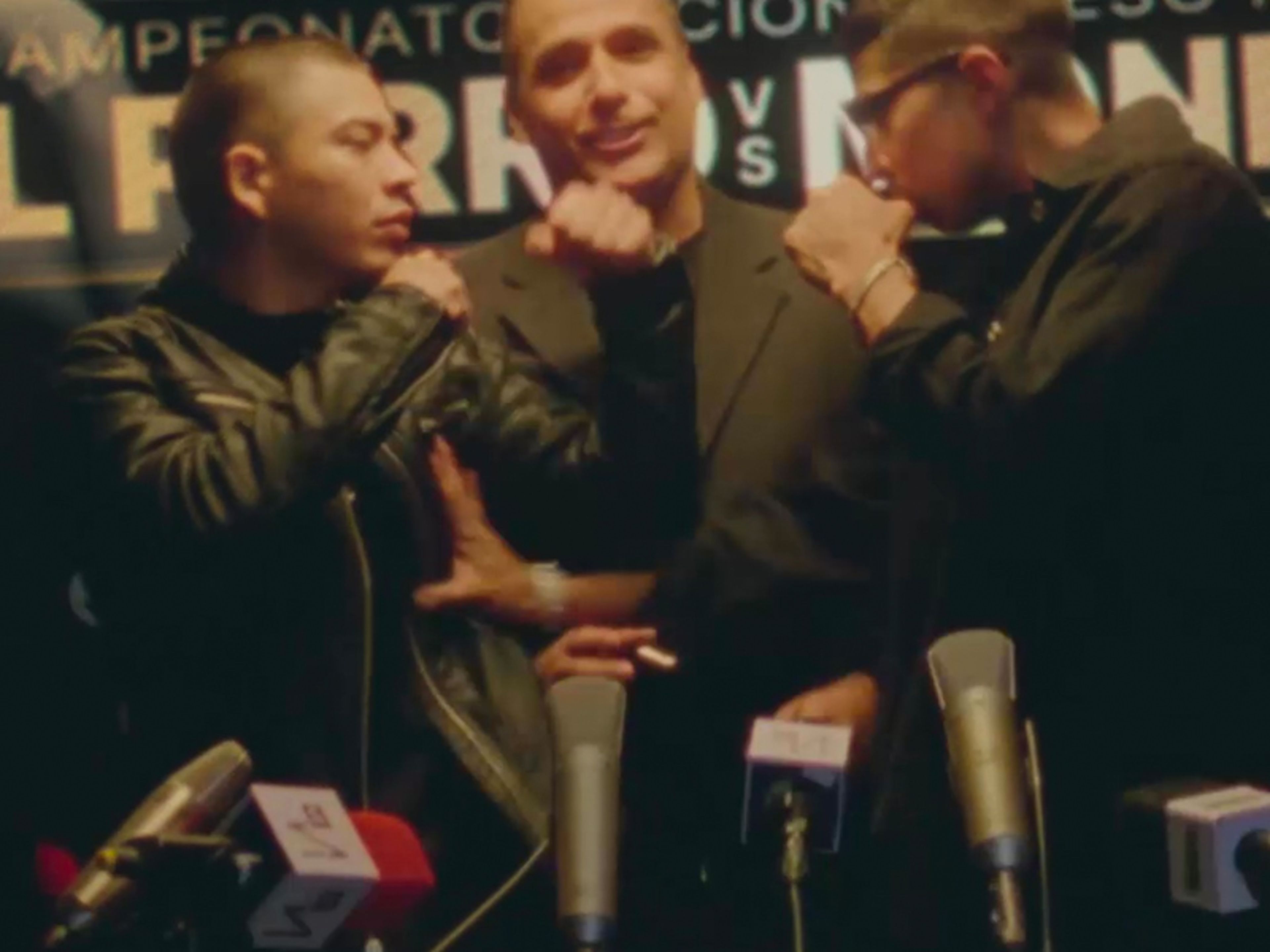 Three boxers standing in front of microphones / at a press conference