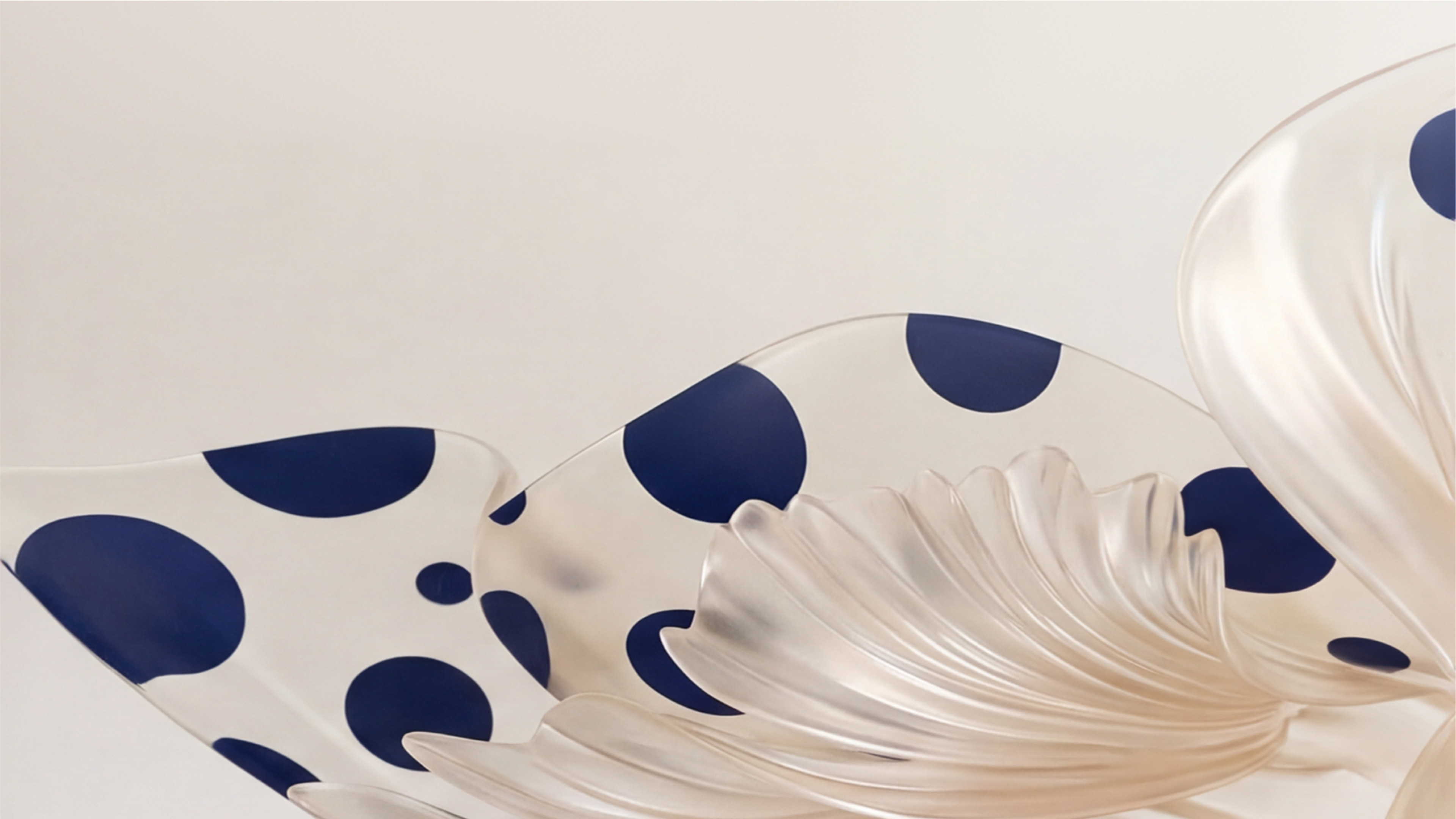 An abstract digital rendering featuring white and translucent pearlescent curved forms with dark blue polka dots against a off-white background.