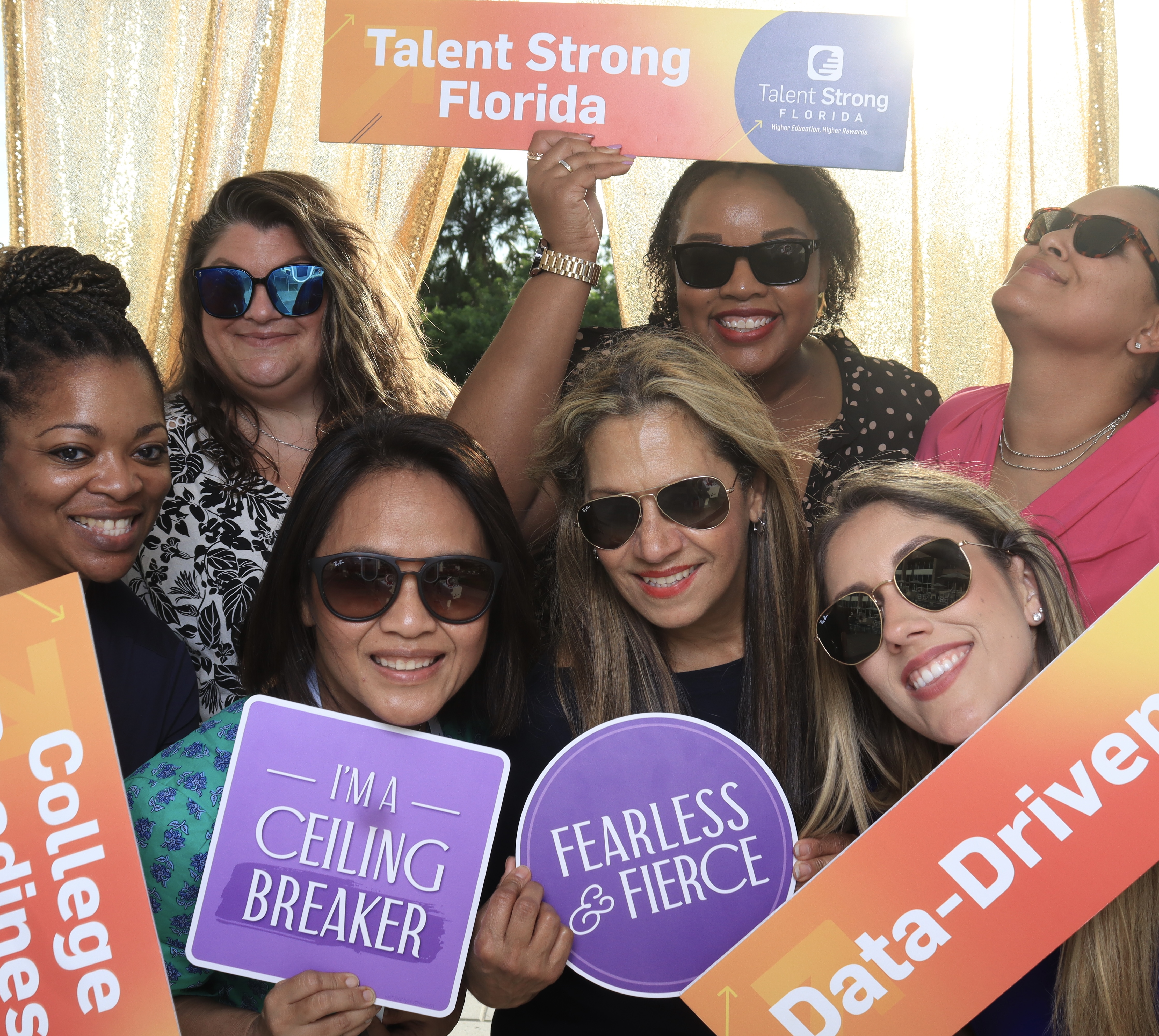 Attendees holding branded signs at a Talent Strong Florida conference activation in Tampa
