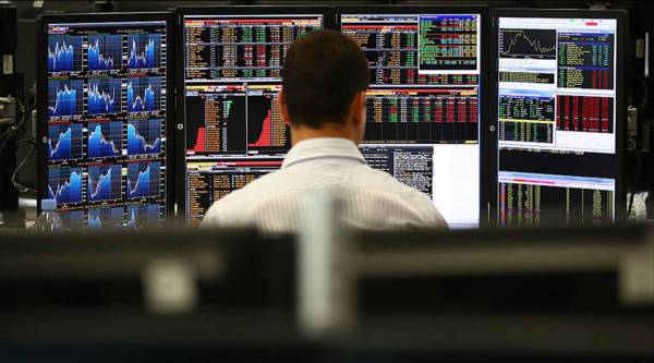 LONDON, ENGLAND - OCTOBER 20:  An employee views trading screens at the offices of Panmure Gordon and Co on October 20, 2014 in London, England. Markets stabilised over the weekend following global turbulence amid fears over the Ebola virus and global economic concerns.  (Photo by Carl Court/Getty Images)
