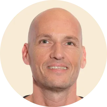 bald man smiling, close-up portrait with neutral background