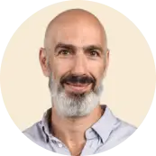 bearded man smiling in light shirt, neutral background, professional portrait with round frame, friendly expression