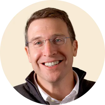 happy man with glasses smiling, portrait of a man in a round frame wearing a dark jacket