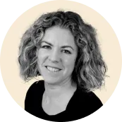 portrait of a smiling woman with curly hair against a light background, professional headshot with engaging expression