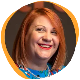 smiling woman with red hair in colorful dress, bright background with soft edges and cheerful expression