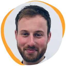 smiling man with short brown hair and beard on a light background, professional headshot with a soft orange circular border