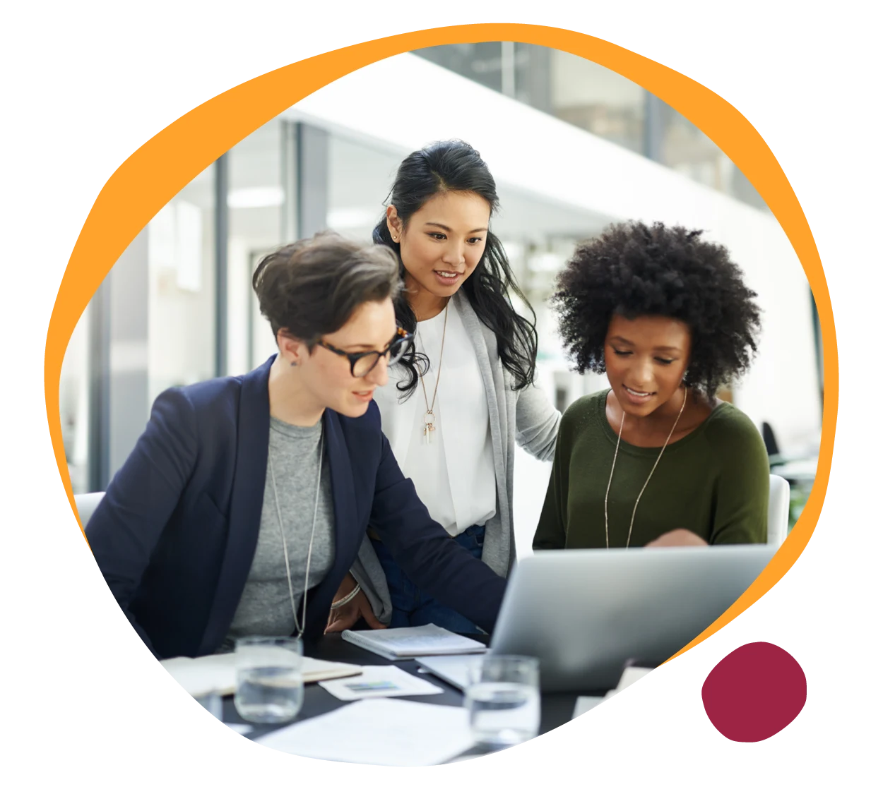 collaborative women analyzing data on laptop, diverse professionals engaged in teamwork in modern workspace